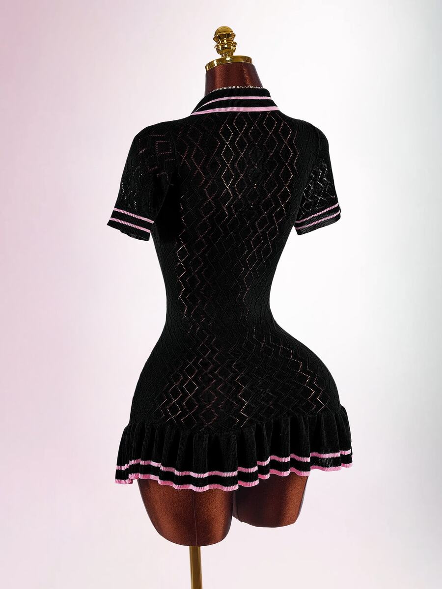 Back view of black fitted knit polo mini dress with geometric openwork pattern and pleated pink-striped hem
