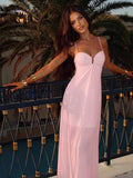 Front view of baby pink spaghetti strap gathered bodice maxi dress on balcony