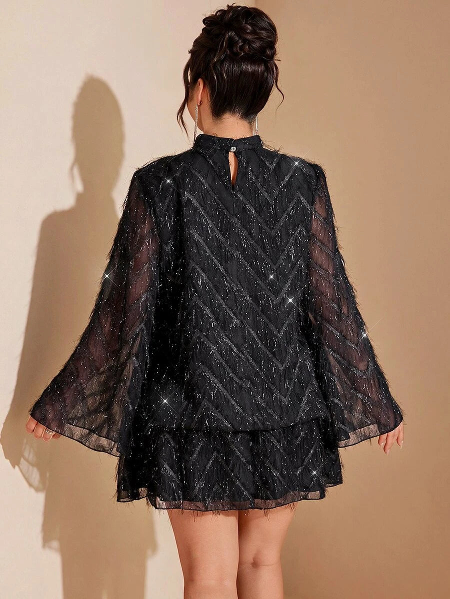 Front view of black short layered dress with sheer flared sleeves, sparkling chevrons and a high collar