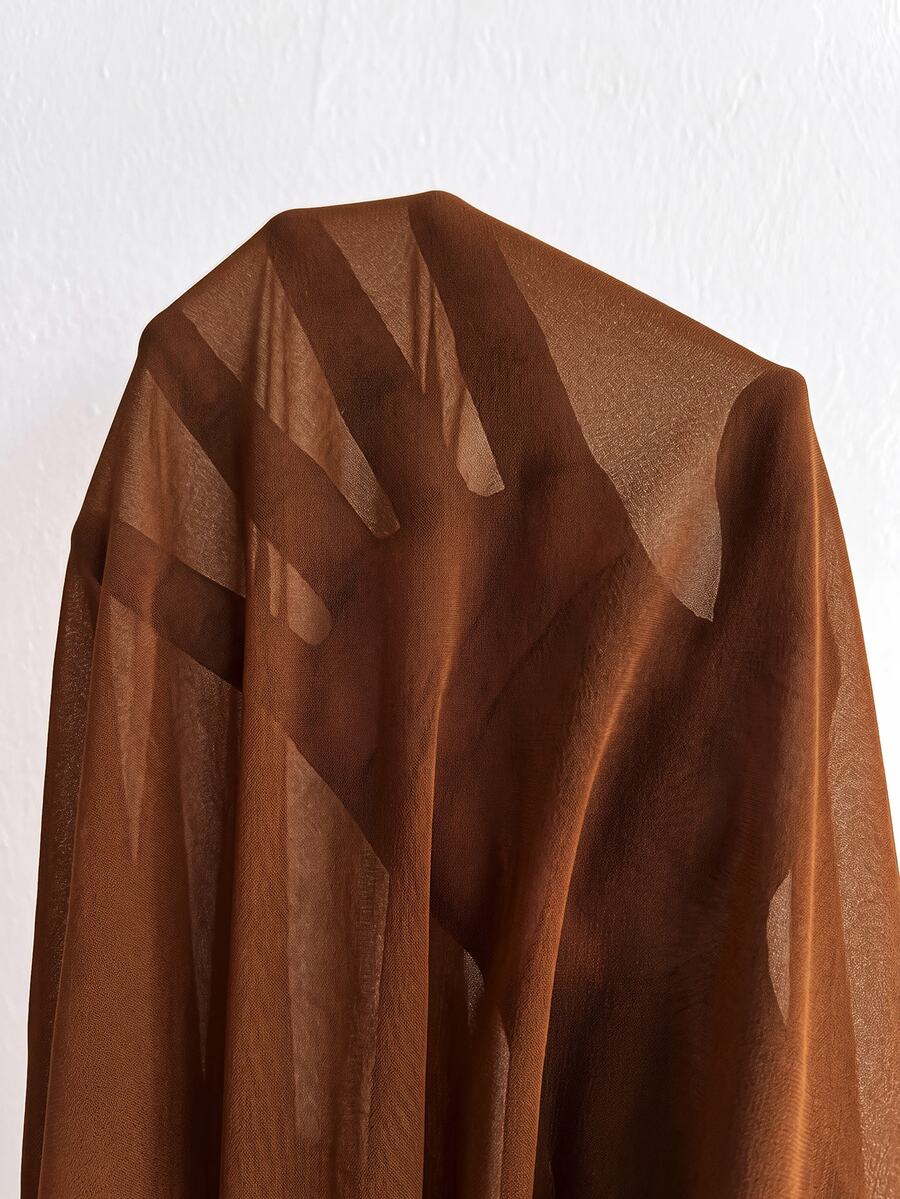 Close-up of translucent brown sleeve fabric and gathered bishop-sleeve cuff on the formal dress