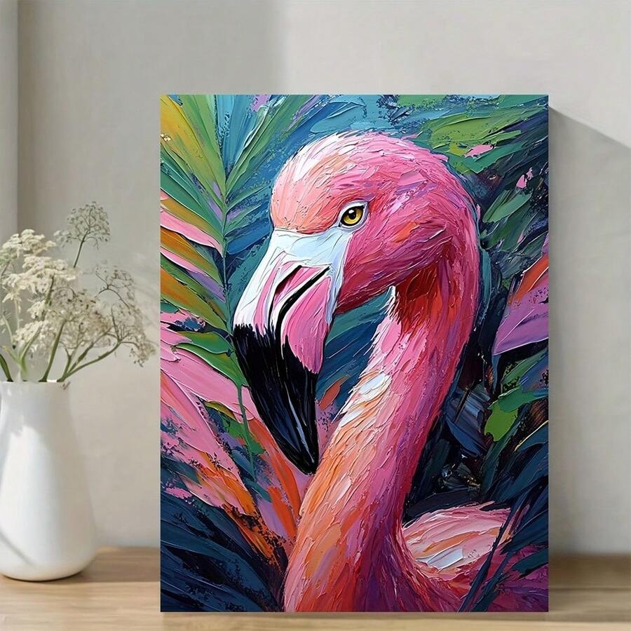 Pink flamingo canvas wall art on a tabletop beside a white vase and dried flowers