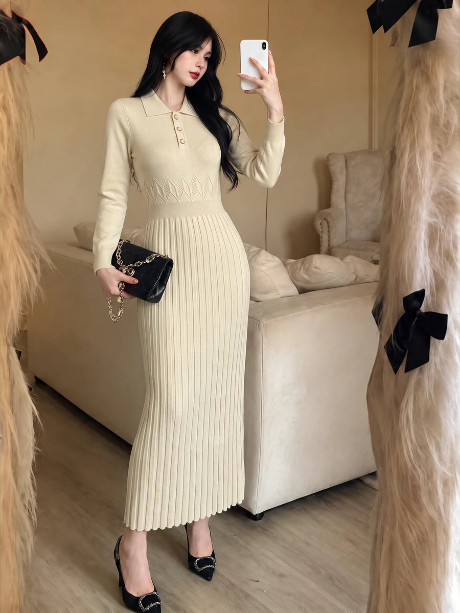 Front view of a model wearing an ivory apricot polo-collar knit dress with button placket, patterned waist and pleated long skirt