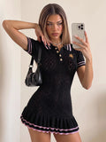 Front view of black knit polo mini dress with pink-striped collar and cuffs, gold buttons, horse embroidery, and pleated hem