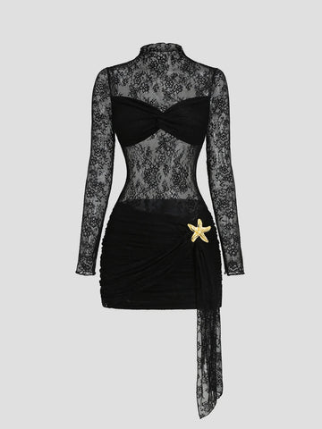Front view of black lace ruched bodycon mini dress with long mesh sleeves and rhinestone starfish brooch