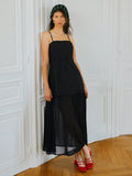 Effortlessly chic and undeniably versatile, this black maxi dress is your new go-to for everything from autumn getaways to nights out on the town. The relaxed loose fit skims your silhouette without clinging, while delicate spaghetti straps keep things breezy and elegant. A sheer panel adds an unexpected touch of intrigue and dimension to the woven fabric. Whether you're sipping cocktails or exploring new destinations, this dress transitions seamlessly from day to evening with just a change of accessories. 