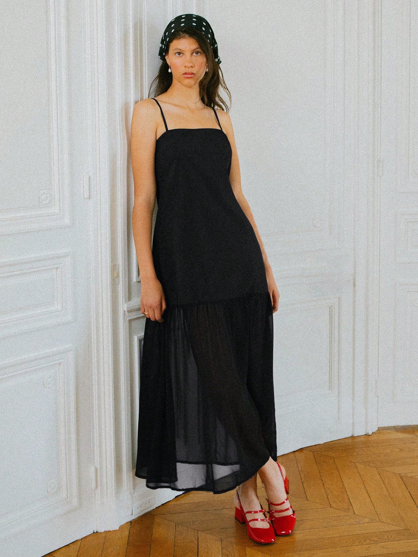 Effortlessly chic and undeniably versatile, this black maxi dress is your new go-to for everything from autumn getaways to nights out on the town. The relaxed loose fit skims your silhouette without clinging, while delicate spaghetti straps keep things breezy and elegant. A sheer panel adds an unexpected touch of intrigue and dimension to the woven fabric. Whether you're sipping cocktails or exploring new destinations, this dress transitions seamlessly from day to evening with just a change of accessories. 