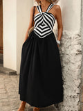 Front view of black and white striped halter midi dress with flowing black skirt
