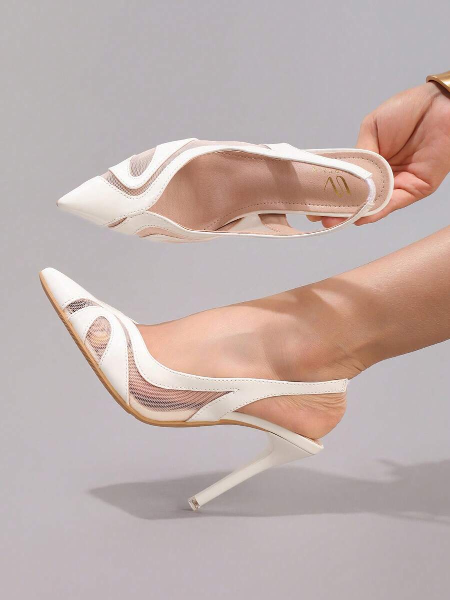 Top side view of white pointed toe pumps with open back strap and beige insole