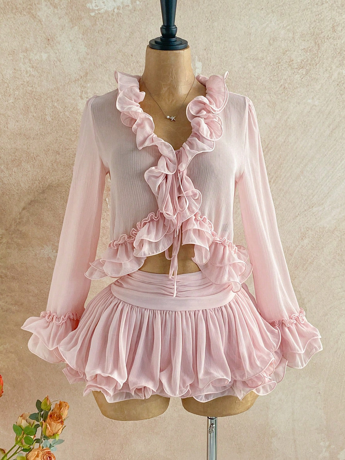 Embrace your inner free spirit with this enchanting two-piece set! The delicate ruffle tie-front cardigan layers beautifully over the blush pink mini skirt, creating an effortlessly chic silhouette that's perfect for brunch dates or weekend adventures. Mix bohemian elegance with modern flair—this pairing brings that coveted boho-chic vibe without trying too hard. Whether you're dressing it up with heels or keeping it casual with sneakers, this set is your new go-to for looking put-together and playfully sty