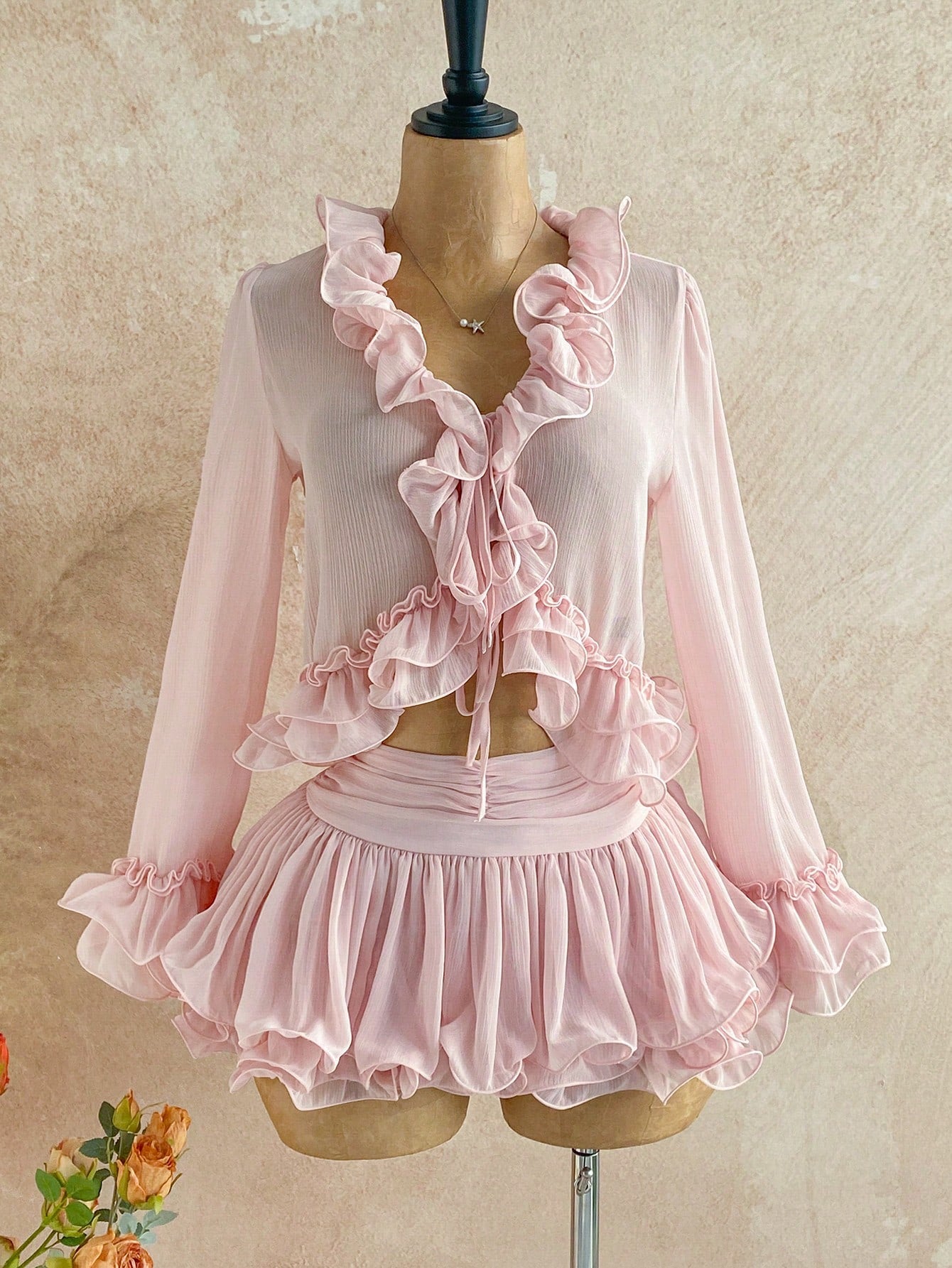 Embrace your inner free spirit with this enchanting two-piece set! The delicate ruffle tie-front cardigan layers beautifully over the blush pink mini skirt, creating an effortlessly chic silhouette that's perfect for brunch dates or weekend adventures. Mix bohemian elegance with modern flair—this pairing brings that coveted boho-chic vibe without trying too hard. Whether you're dressing it up with heels or keeping it casual with sneakers, this set is your new go-to for looking put-together and playfully sty