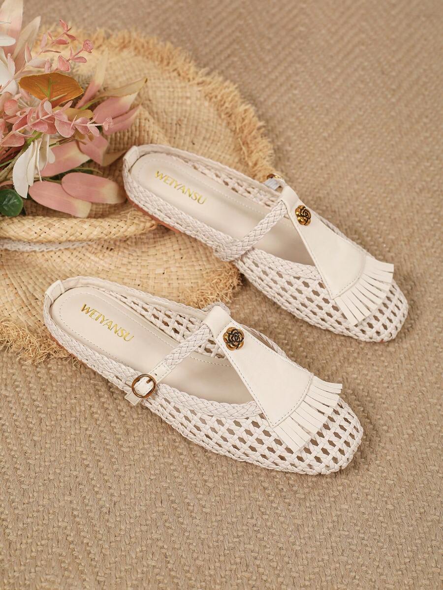 Angled overhead view of ivory woven Mary Jane flats with floral T-straps and fringe