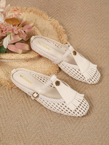 Angled overhead view of ivory woven Mary Jane flats with floral T-straps and fringe