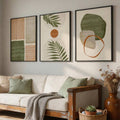Living room crop of three earth-tone abstract botanical prints in black frames