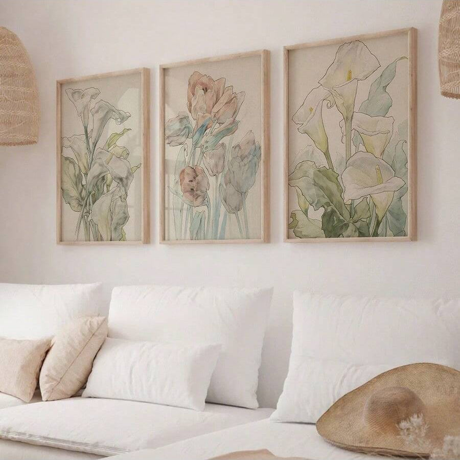 Set of three watercolor tulip and lily canvas prints above a white sofa in a boho room