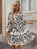 Embrace effortless bohemian style with this versatile V-neck tassel cuff dress. Featuring a vibrant multicolor colorblock and all-over print design, this A-line silhouette showcases a high waist, three-quarter sleeves, and playful ruffle hem with fringe detailing. The notched neckline and contrast binding add sophisticated touches, while the flounce hem creates movement and flair. Perfect for vacations, fall adventures, and festive occasions, this regular-fit dress transitions seamlessly from day to night. 
