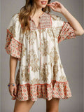 Front view of tan and coral botanical patchwork mini dress with puff sleeves and ruffle hem