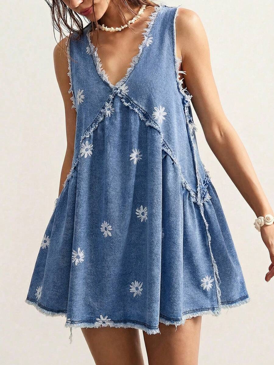 Front model view of faded blue daisy denim mini dress with deep V-neck and frayed hem