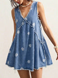 Front model view of faded blue daisy denim mini dress with deep V-neck and frayed hem