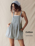 Front three-quarter view of light gray pinstriped overall romper with hands in side pockets