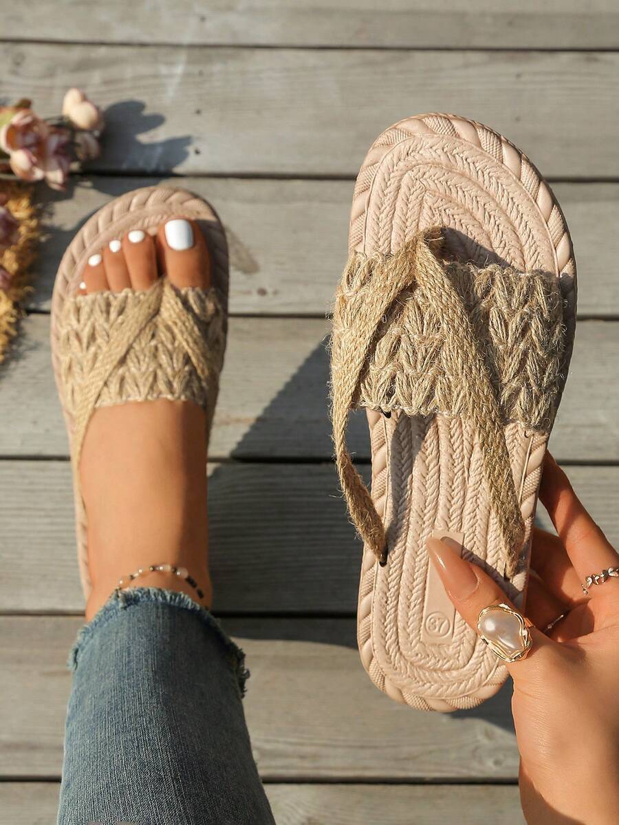 Overhead on-foot view of khaki braided toe-post sandals on a wooden deck