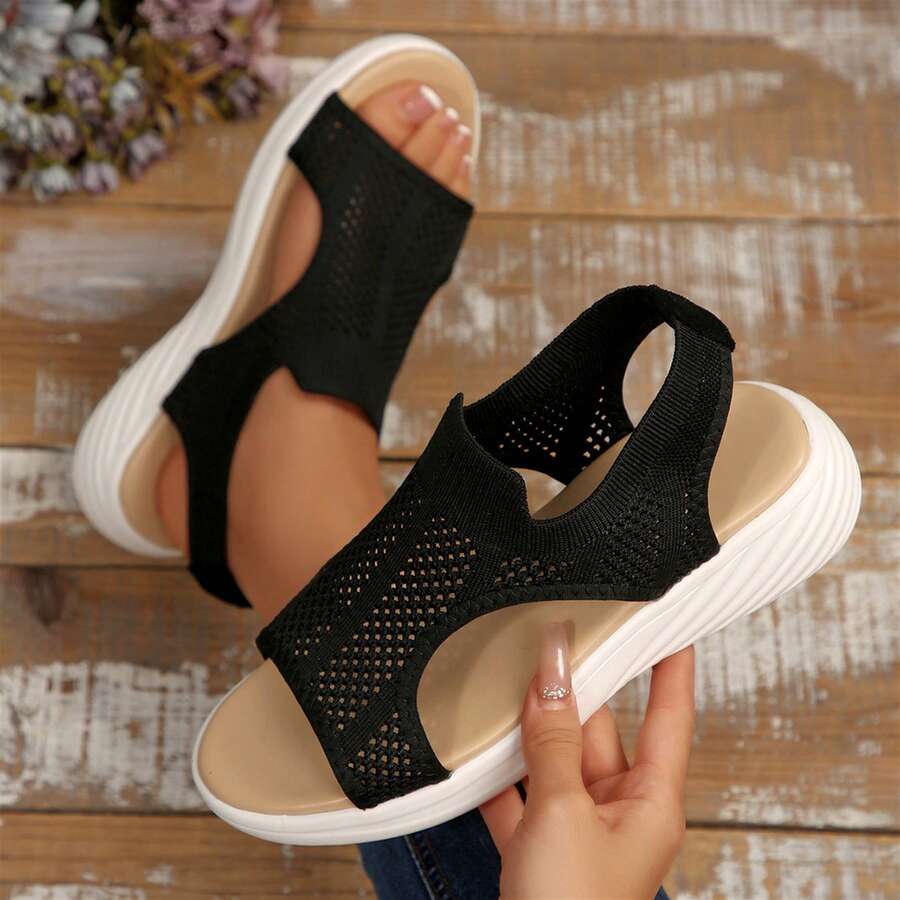 Top view of black knitted mesh slingback wedge sandals shown held and worn