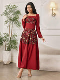 Front view of burgundy A-line maxi dress with floral embroidered mesh bodice and long puff sleeves