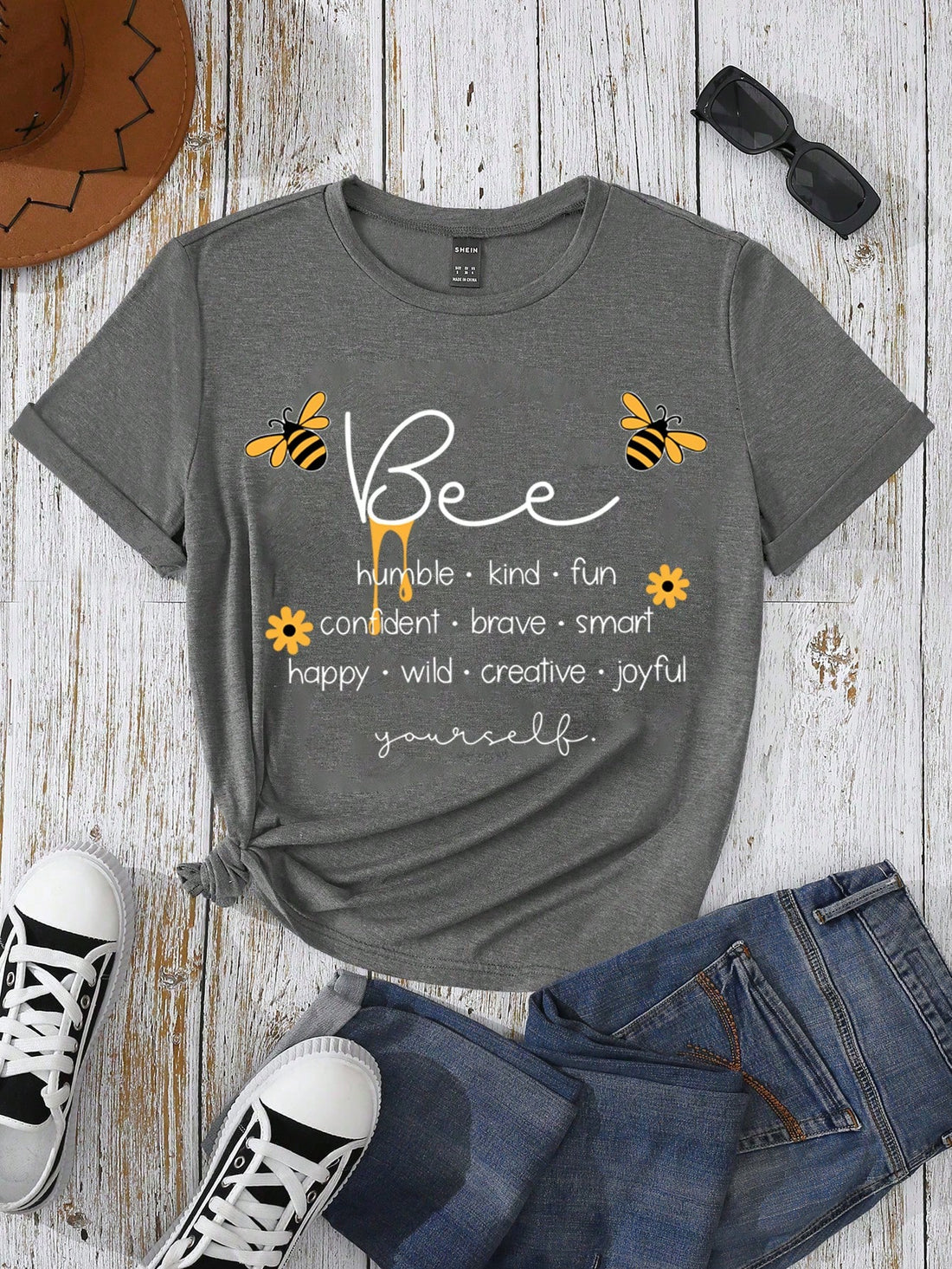 Be the queen bee of fashion with our Buzzing Style women's short sleeve graphic tee! Featuring a playful bee print and trendy slogan, this tee will make you stand out in the hive. With a comfortable fit and quirky design, you'll be buzzing with confidence. (Tee-hee)