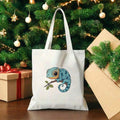 Front staged view of white canvas tote bag with blue chameleon branch print