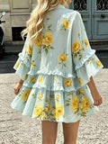 Rear street view of mint floral smock mini dress with wide sleeves and gathered tiers