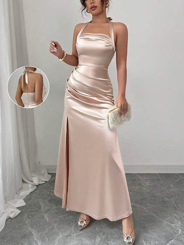 View 1 of champagne satin halter slit maxi dress with open back, ruched waist, neck tie straps, and high slit