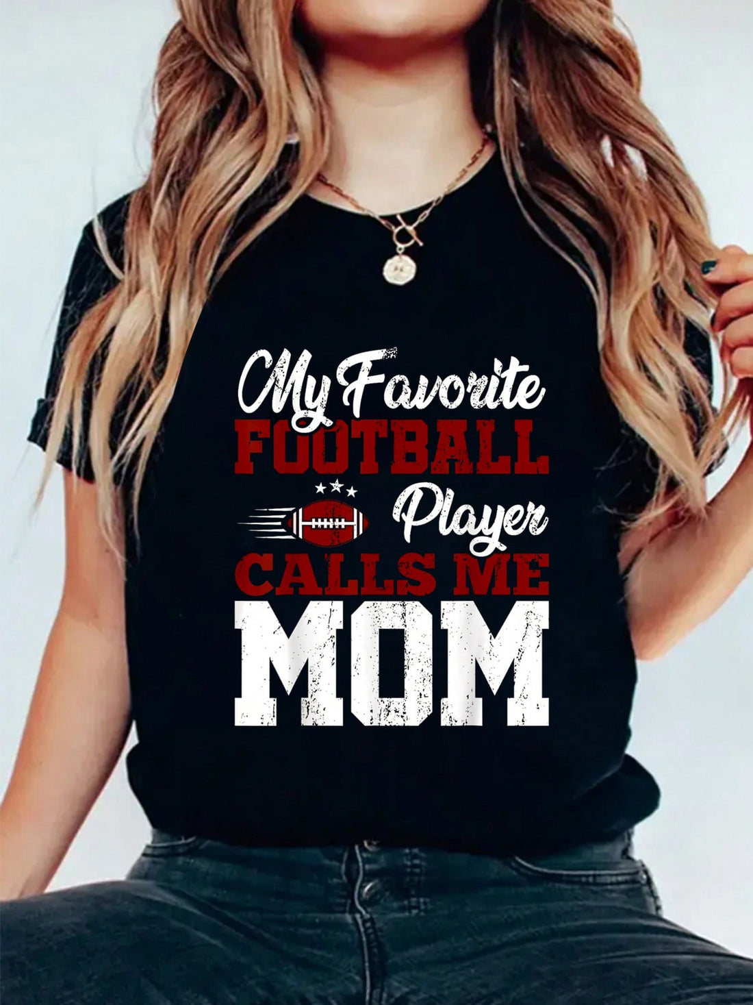 Celebrate Mother's Day with the Champion Mom: American Football Player Graphic Tee. Show off your love for both your mom and the game of football with this unique and playful shirt. Perfect for any football-loving mom, this tee will surely bring a smile to her face (and maybe even score you some brownie points).