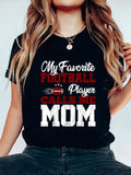 Celebrate Mother's Day with the Champion Mom: American Football Player Graphic Tee. Show off your love for both your mom and the game of football with this unique and playful shirt. Perfect for any football-loving mom, this tee will surely bring a smile to her face (and maybe even score you some brownie points).