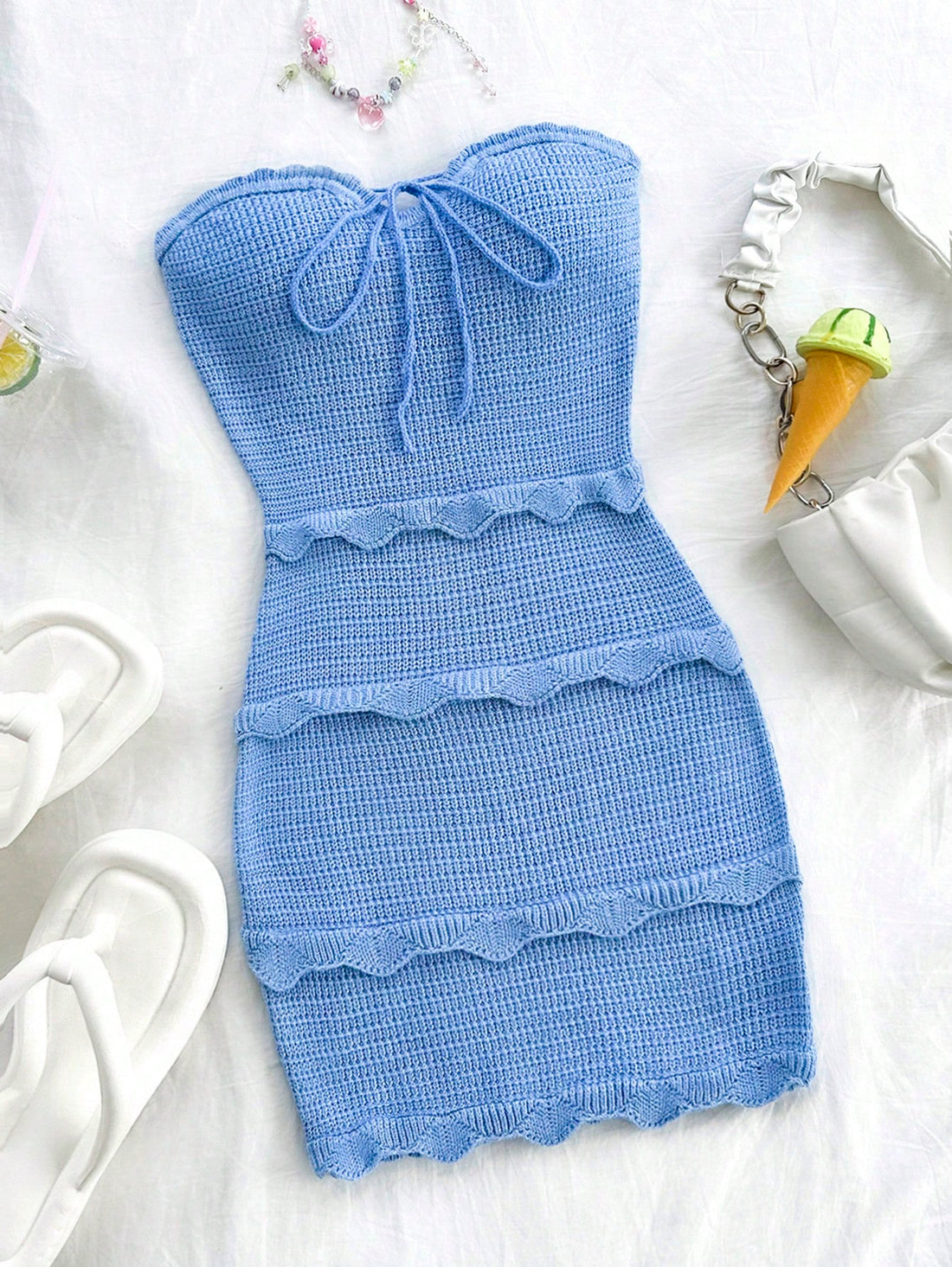 This charming blue strapless dress features a wavy hemline and a delicate bowknot detail, making it the perfect outfit for any summer occasion. The strapless design provides a flattering silhouette, while the wavy hem adds a touch of elegance. Enjoy the warm weather in style with this versatile and fashionable dress.