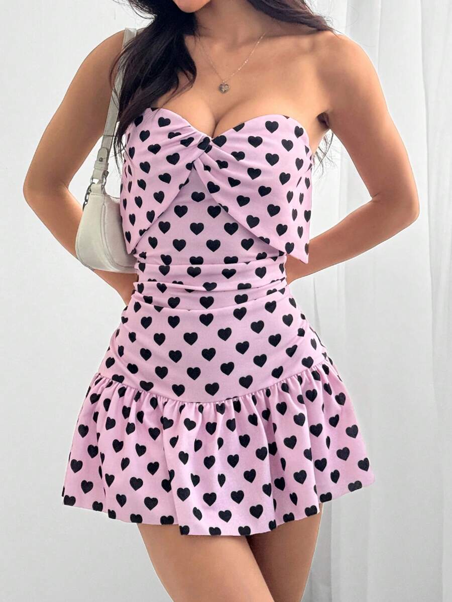 Effortlessly exude charm in this mini cami dress with a heart-shaped print and ruched detailing. Perfect for a fun and flirty style that's easy to achieve. Indulge in your playful side with this charming dress.