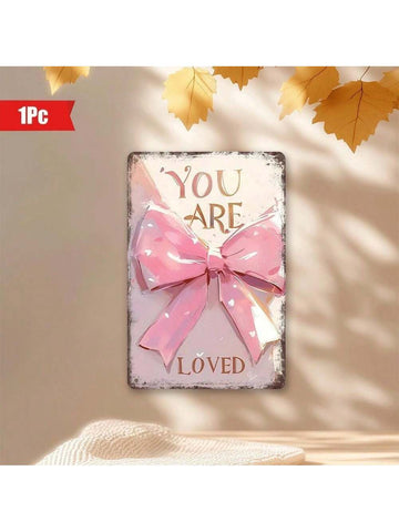 Add a charming touch to your home or café with this 'You Are Loved' Pink Bow Wall Art. The 8x12 inch decorative metal plaque features a sweet message to brighten any space. Show someone you care with this unique and playful piece of décor.