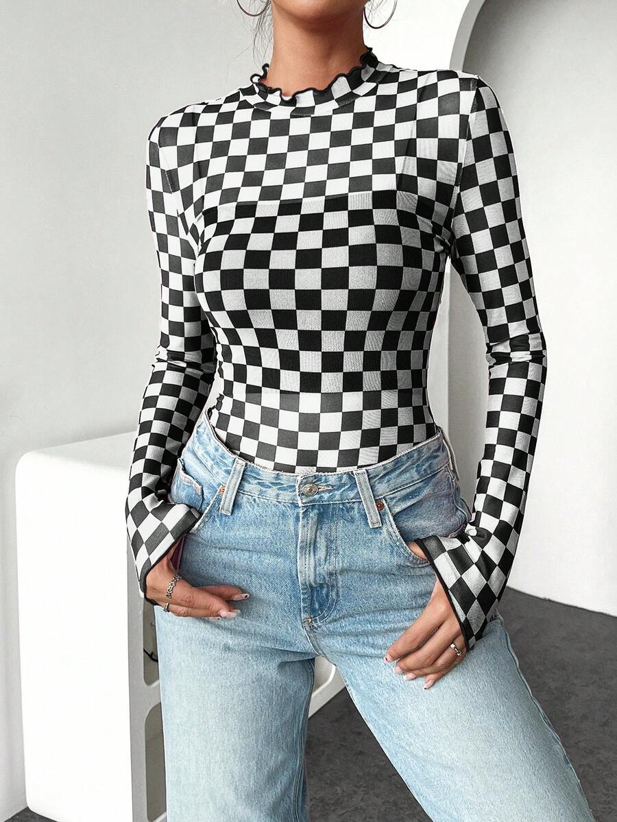 Front three-quarter view of black and white checkerboard fitted knit top with stand collar