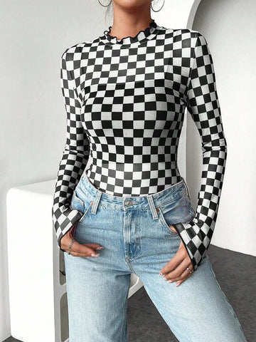 Front three-quarter view of black and white checkerboard fitted knit top with stand collar