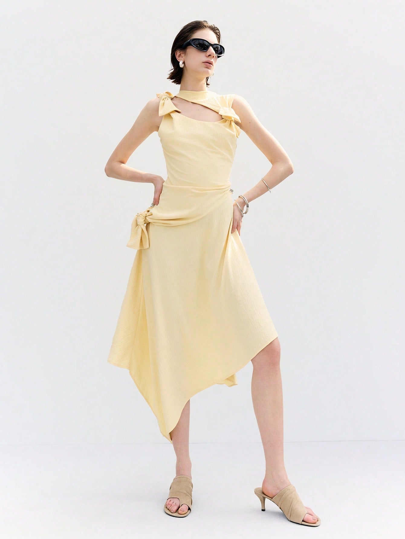 Step into sunshine with this playful butter yellow dress featuring a chic apricot twist. Its asymmetrical hem and knotted drop waist create a fun, flirty silhouette that moves with you. Perfect for effortless style that brightens any day.
