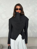 Front view of dark charcoal short jacket with high collar, diagonal wrap panel and small gold-tone fasteners