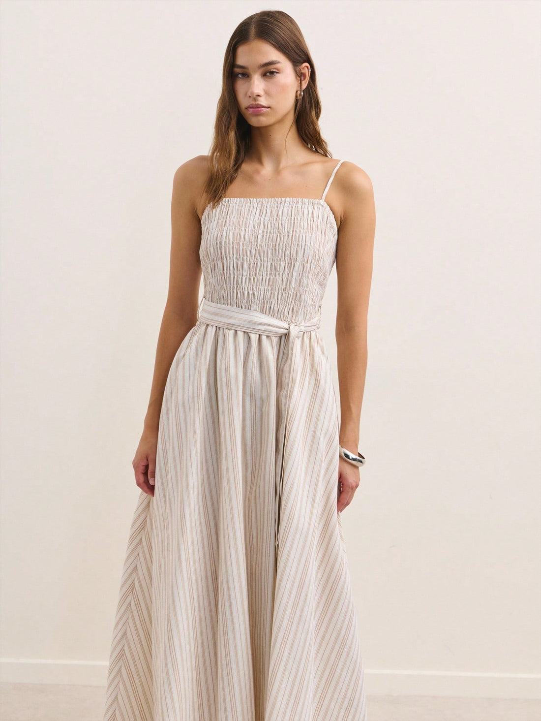 Effortlessly chic meets comfort in this stunning beige maxi dress! Featuring delicate smocking details that add texture and visual interest, wide straps for a flattering fit, and a coordinating belt to cinch your silhouette just right. The flowing maxi length keeps things elegant while the neutral tone pairs beautifully with everything in your closet. Whether you're heading to a summer garden party or layering up for crisp fall days, this versatile piece transitions seamlessly through the seasons. Dress it 