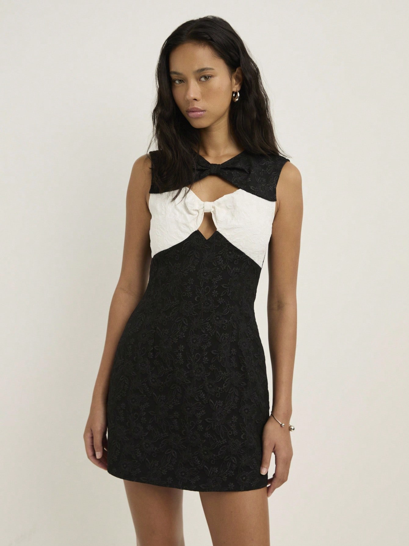 Elevate your autumn wardrobe with this chic black fitted mini dress that's basically a style shortcut. The crisp white bow details add a playful twist that works whether you're heading to brunch or a night out. The fitted silhouette flatters your figure while the mini length keeps things fun and flirty. Pair it with your favorite boots or sneakers—this dress is versatile enough to handle whatever vibe you're going for. Simple, sophisticated, and seriously stylish.