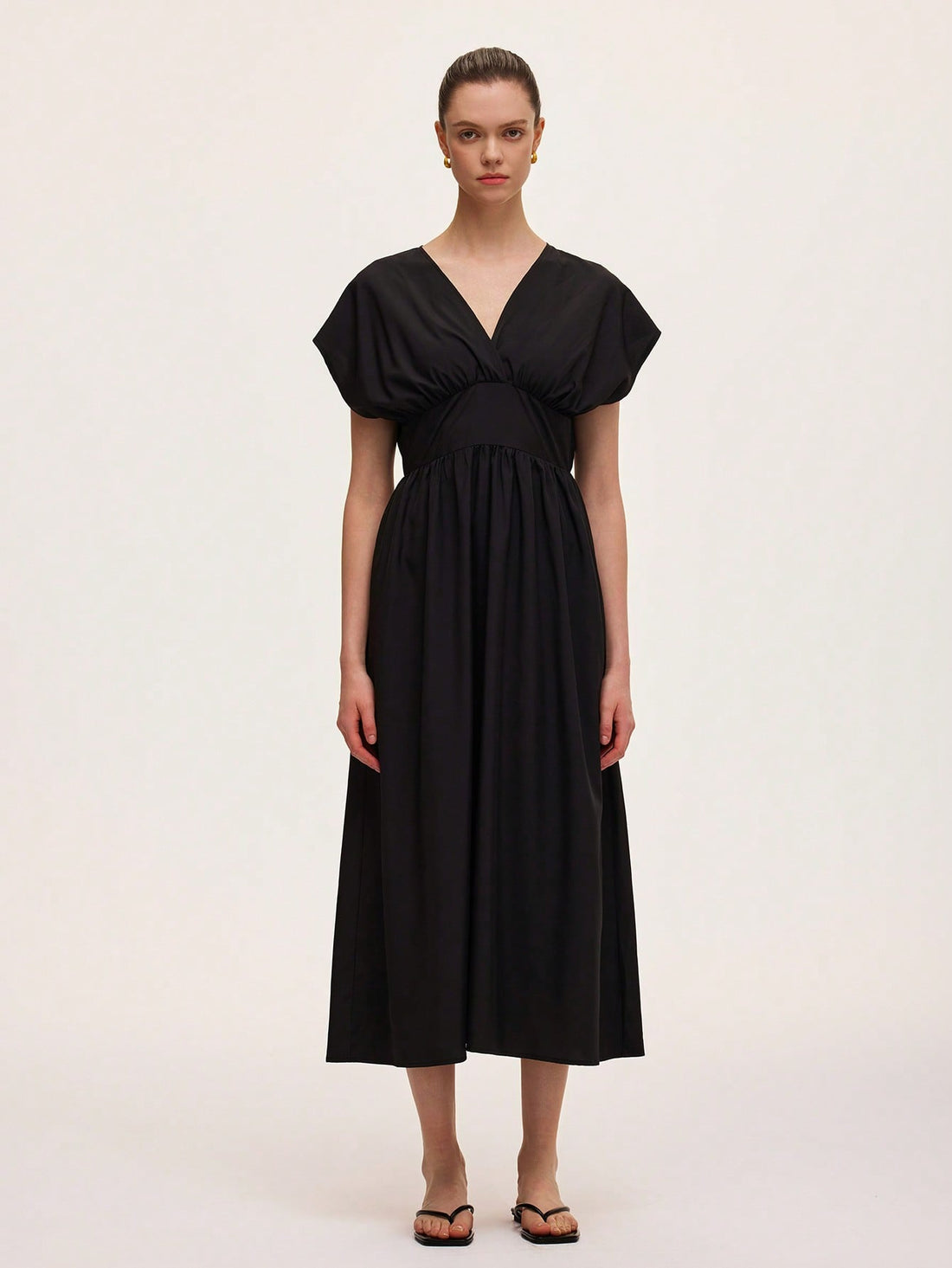 Step out in style with this chic black V-neck dress featuring a flattering draped design and a cinched waist that effortlessly highlights your silhouette. Perfect for any occasion, it combines comfort and elegance with a playful twist, making you feel confident and ready to turn heads wherever you go.
