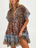 Front three-quarter view of brown mixed-print deep-V mini dress with striped ruffle hem
