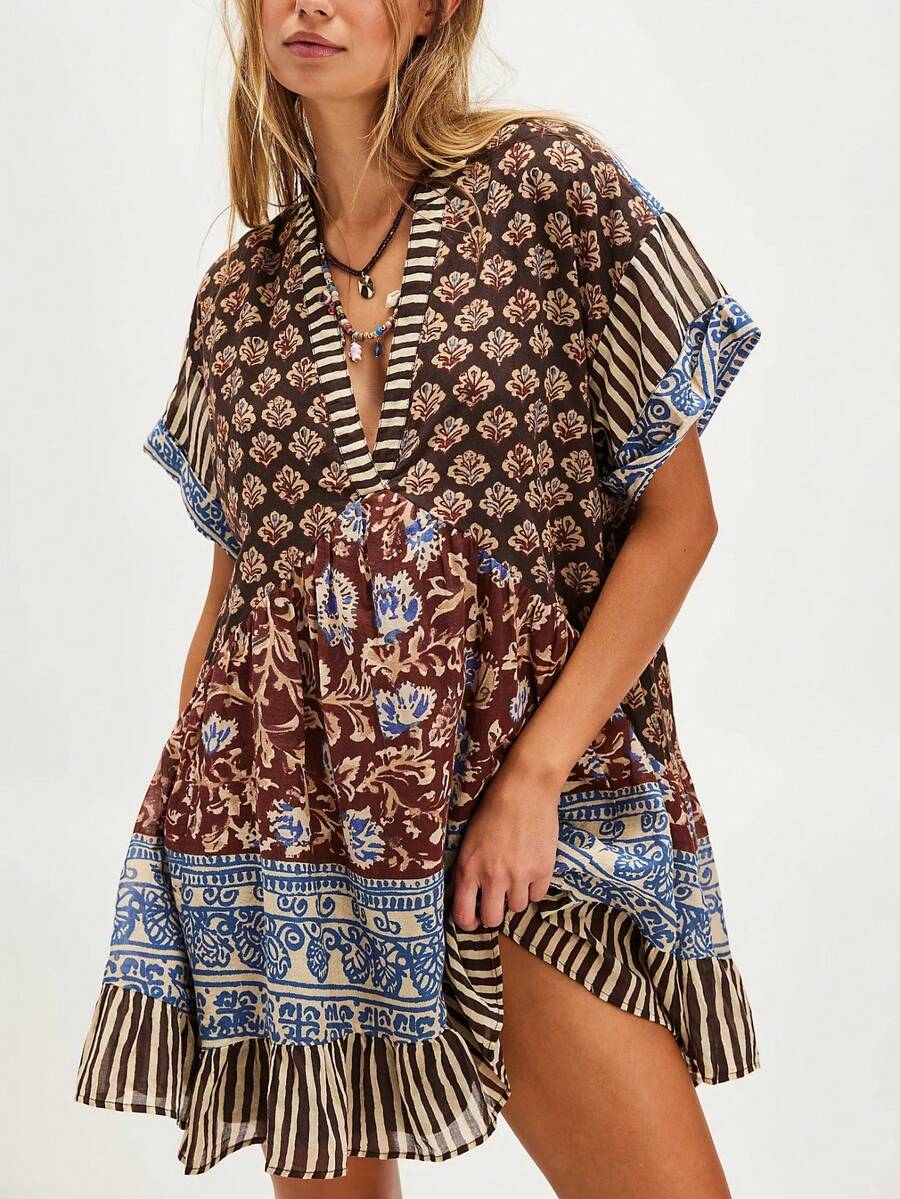 Front three-quarter view of brown mixed-print deep-V mini dress with striped ruffle hem