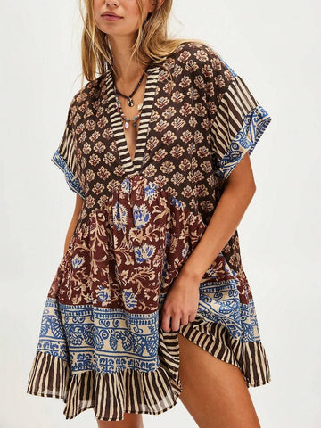 Front three-quarter view of brown mixed-print deep-V mini dress with striped ruffle hem
