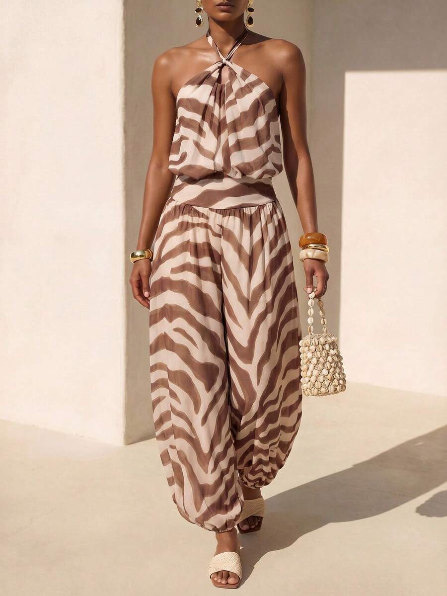 Front courtyard view of brown striped halter jumpsuit with twisted neckline and harem legs