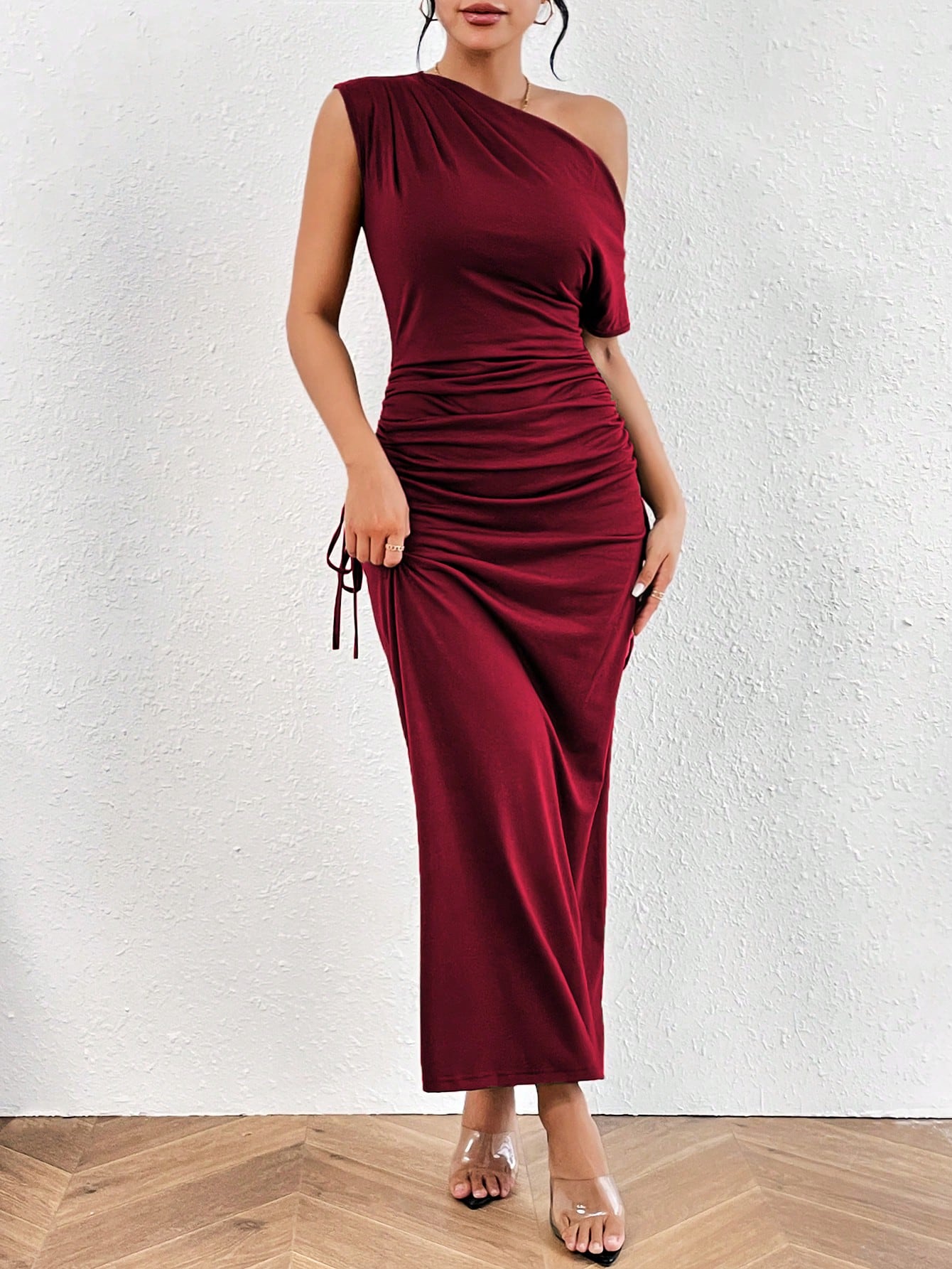 Make a statement with this chic burgundy maxi dress! The asymmetrical neck adds a touch of uniqueness while the ruched sides provide a flattering fit. Perfect for any occasion, this dress is both stylish and comfortable. (And who doesn't love a good ruche?)