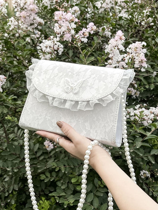 The Chic Butterfly Applique Faux Pearl Trim Square Bag is the perfect accessory for any occasion. With its elegant design and faux pearl embellishments, it adds a touch of sophistication to your outfit. Its square shape and spacious interior make it functional and stylish. Elevate your look with this must-have bag.