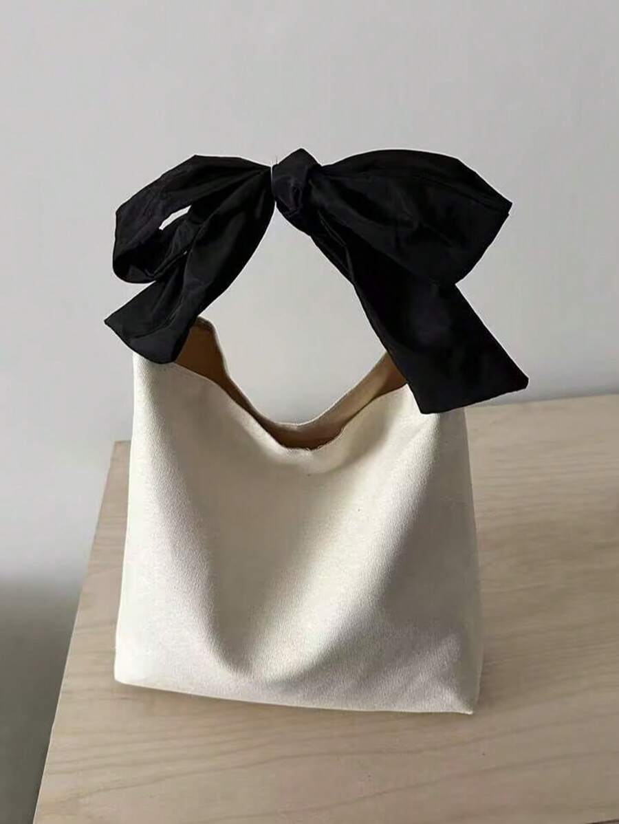 Elevate your everyday style with this chic canvas bow handbag. Crafted from durable 100% polyester, this versatile shoulder tote features a charming bow detail and convenient top handle design. The clean white finish and plain pattern make it effortlessly elegant for any occasion—whether you're heading to school, the office, or a casual date. No-closure design keeps your essentials easily accessible. A timeless piece that transitions seamlessly from day to night.