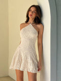 Front view of apricot embroidered halter mini dress with flared skirt